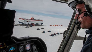 Ein Pilot guckt aus der Luft auf eine Forschungsstation in der Antarktis | © Esther Horvath