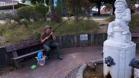 Ein Mann sitzt am Brunnen beim Angeln. | © Sylvia Radtke