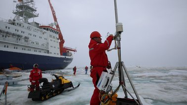 Ein Wissenschaftler deinstalliert ein Messgerät auf einer Eisscholle | © Lisa Grosfeld