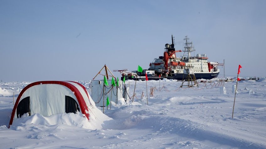 Blick auf ein Eiscamp in der Arktis mit Forschungsschiff im Hintergrund | © Michael Gutsche