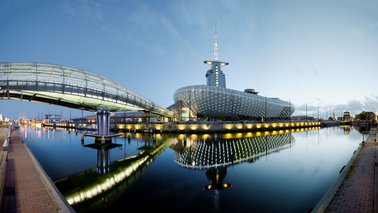 Ein beleuchtetes Gebäude vor einer Wasserfläche bei Nacht | © Marcus Meyer