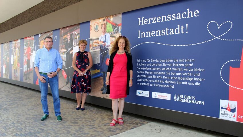 Drei Menschen stehen vor einem bunt beklebten Schaufenster | © Dörte Behrmann (Erlebnis Bremerhaven GmbH)