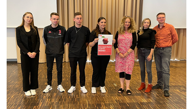 7 Personen stehen nebeneinander und präsentieren einen Plakatentwurf. | © Birte Kemmerling