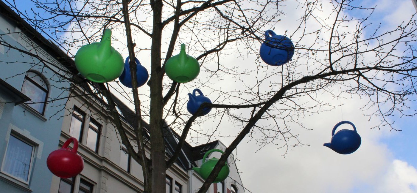 Plastik Gießkannen am Baum ohne Blätter in Lehe