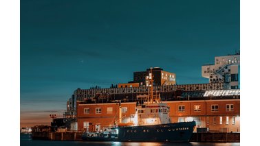 Ein beleuchtetes Schiff steht im Hafen bei Dunkelheit.  | © Christian Wieczerek 