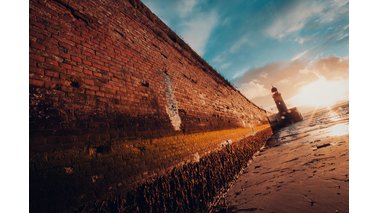 Ein Leuchtturm an einer Wand bei Sonnenuntergang.  | © Christian Wieczerek 