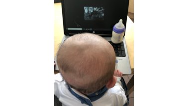 Ein Baby sitzt vor einem Laptop. | © Nadine Baur