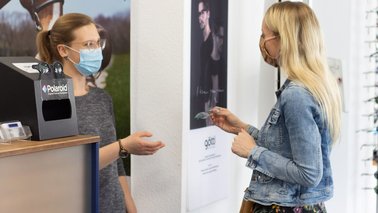 Eine Frau überreicht einer Kundin eine Brille | © Doreen von Oesen-Klein