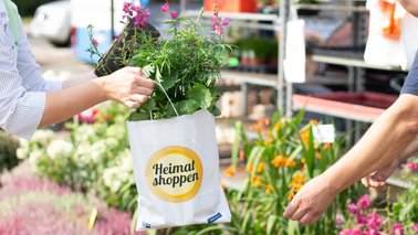 Eine Hand überreicht eine Tüte mit Blumen | © Doreen von Oesen-Klein