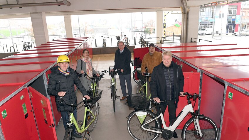 5 Menschen stehen mit ihren Fahrrädern vor roten Fahrradboxen. | © Wolfhard Scheer