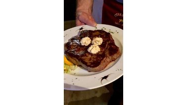 Ein Steak mit Kräuterbutter angerichtet auf einem Teller. 