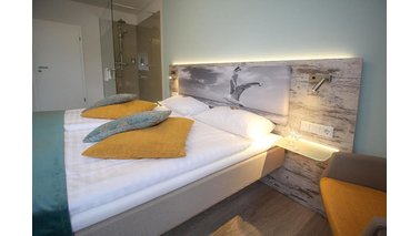 Ein Bett mit Ablage im City-Hotel-Bremerhaven